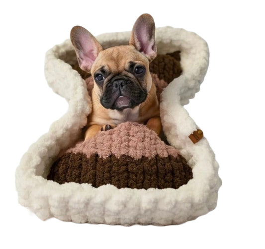 Dog lying in a cozy, brown and white pet bed on a white background