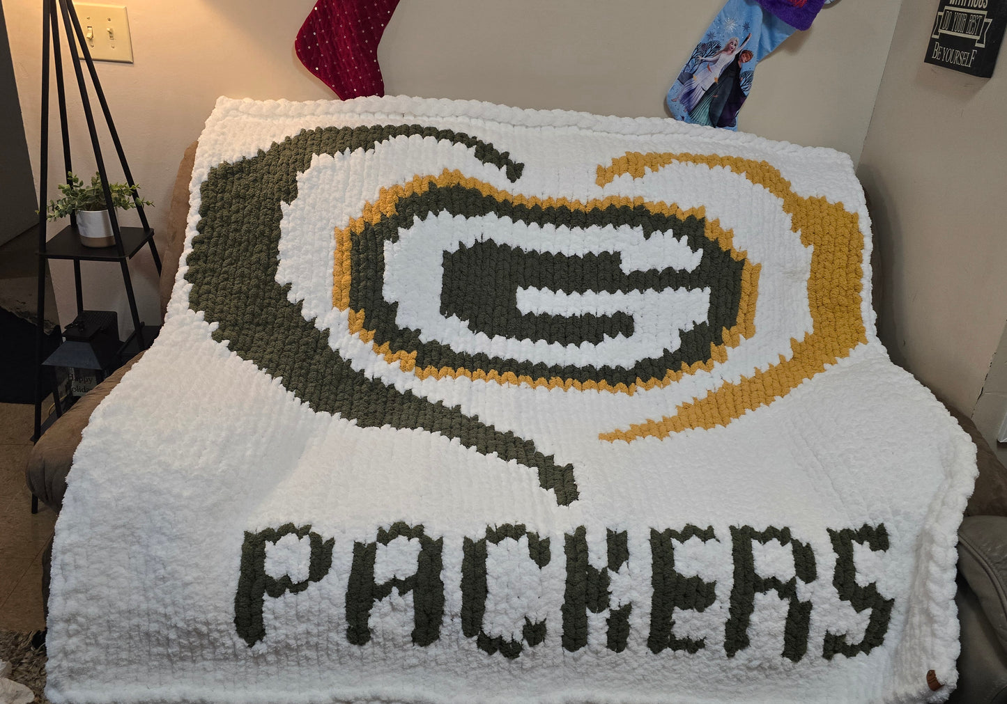 Blanket with Green Bay Packers logo and text in a living room setting