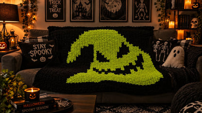 Oogie Boogie chunky-knit blanket draped over a couch in a spooky-themed room, featuring a bold green Oogie Boogie silhouette on a black background with Halloween-inspired decor.
